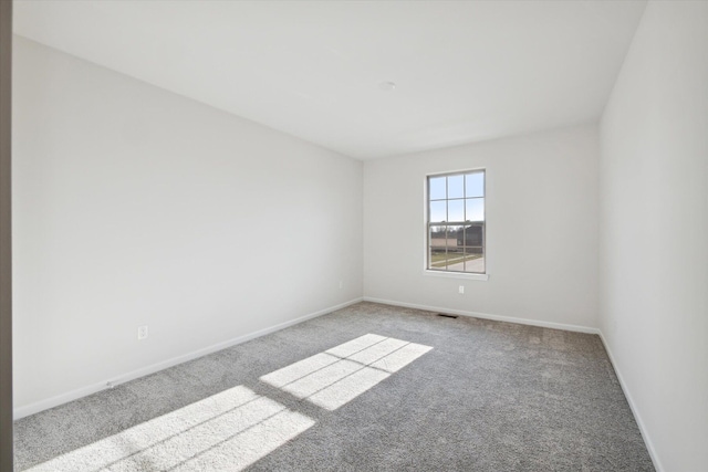 carpeted empty room featuring baseboards