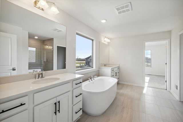 bathroom with a soaking tub, visible vents, a stall shower, and a sink