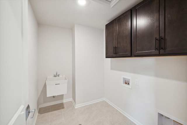 laundry room with light tile patterned floors, cabinet space, hookup for a washing machine, and baseboards