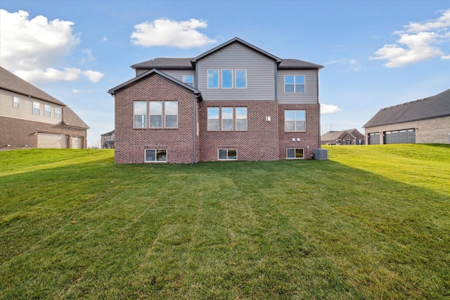 back of house with a yard, central air condition unit, and brick siding