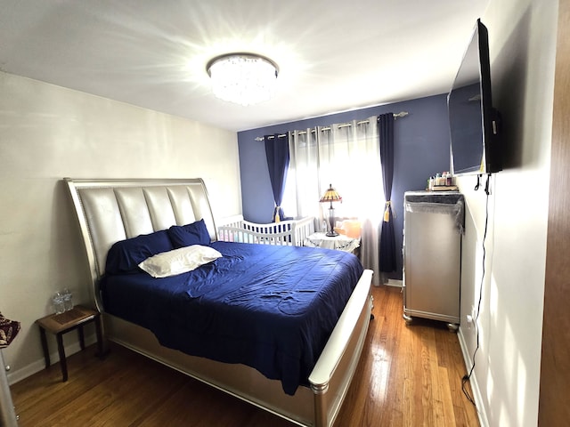 bedroom featuring hardwood / wood-style flooring and a notable chandelier