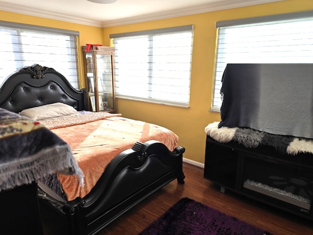 bedroom featuring multiple windows, dark hardwood / wood-style flooring, and ornamental molding