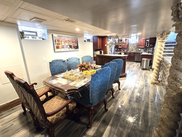 dining room with wood-type flooring and a healthy amount of sunlight