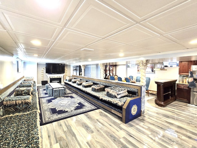 living room featuring plenty of natural light, light hardwood / wood-style floors, and coffered ceiling