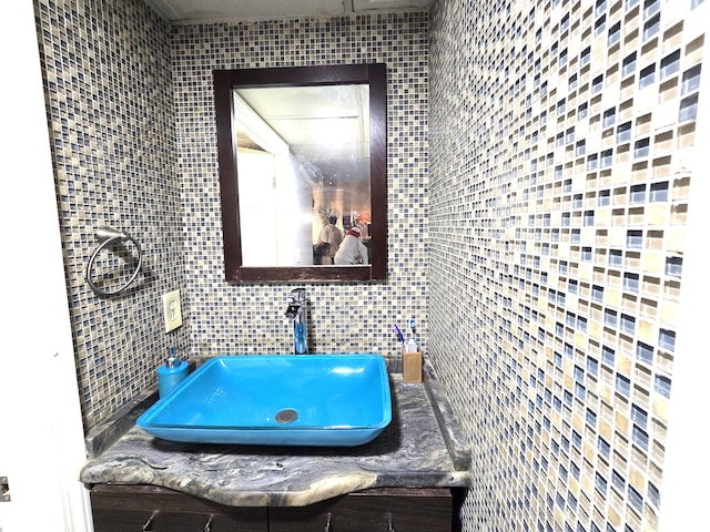 bathroom with backsplash, vanity, and tile walls