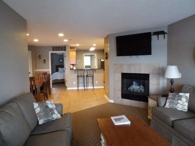 living room with a fireplace and light wood-type flooring