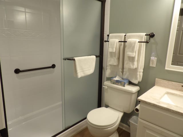 bathroom featuring toilet, vanity, and walk in shower