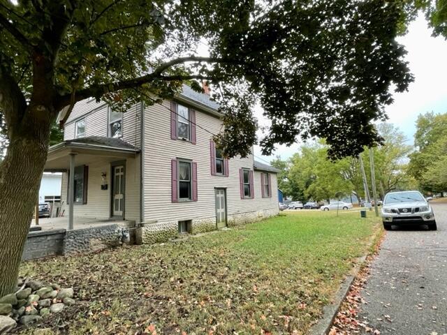 120 Oak St, Hillsdale, MI 49242 - view of side of property with a porch and a lawn