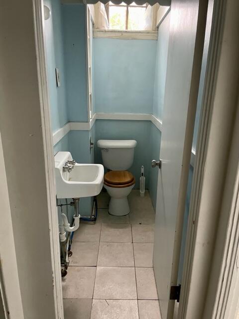 120 Oak St, Hillsdale, MI 49242 - half bath featuring a sink, toilet, and tile patterned flooring