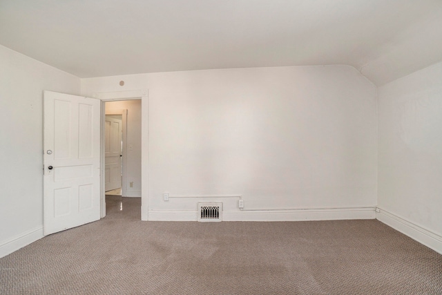 empty room with vaulted ceiling and carpet flooring