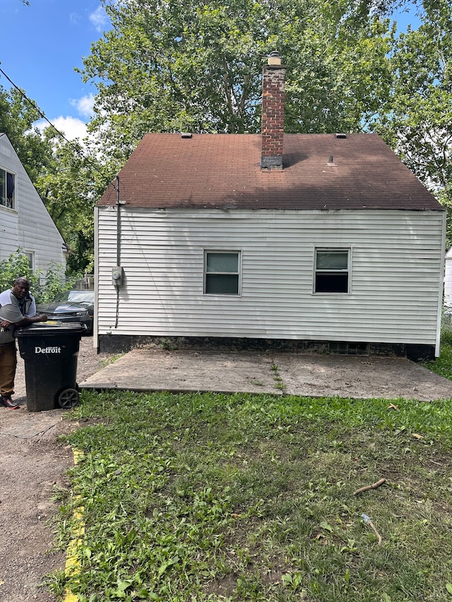 rear view of house featuring a lawn