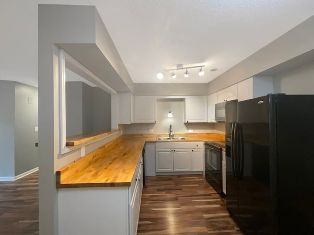 kitchen featuring wood counters, sink, white cabinetry, and black appliances