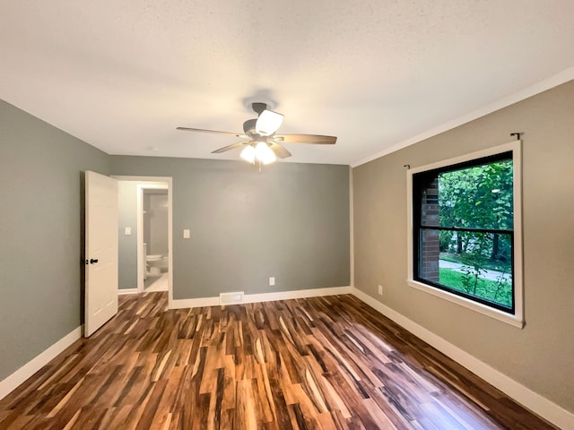 spare room featuring dark hardwood / wood-style flooring, ceiling fan, and crown molding