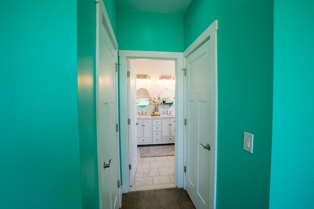 hallway with dark tile patterned flooring and sink