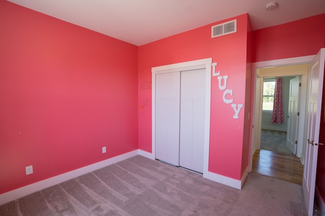 unfurnished bedroom with light carpet and a closet