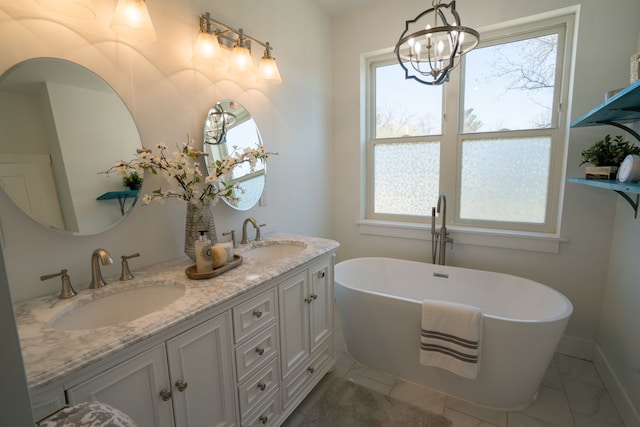 bathroom featuring a washtub, vanity, a healthy amount of sunlight, and an inviting chandelier