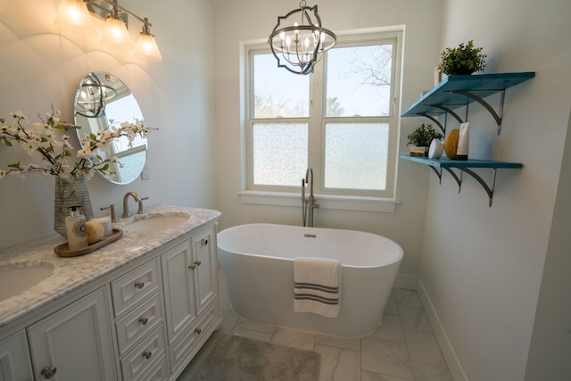 bathroom featuring a washtub, vanity, and an inviting chandelier