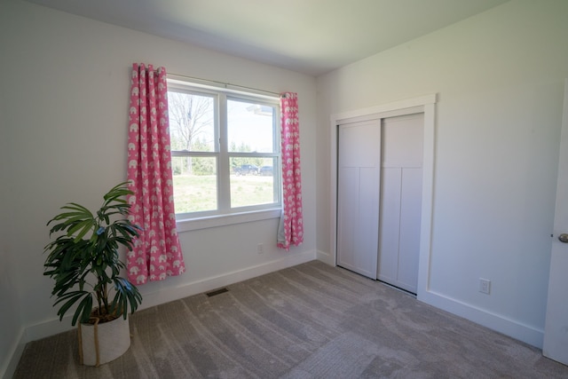 unfurnished bedroom featuring carpet floors and a closet