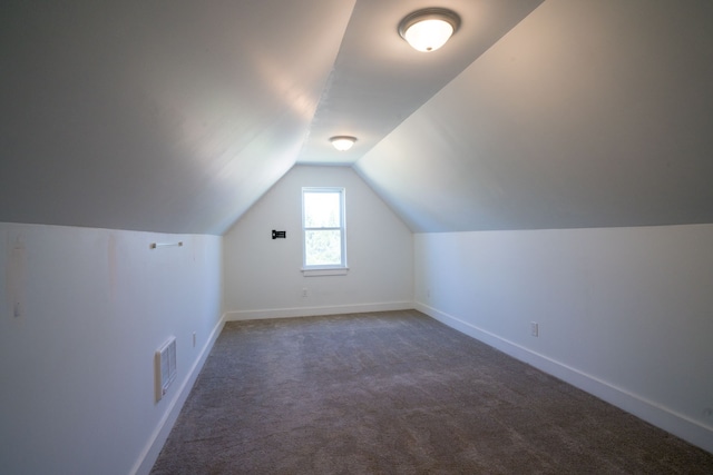 bonus room featuring dark carpet and lofted ceiling