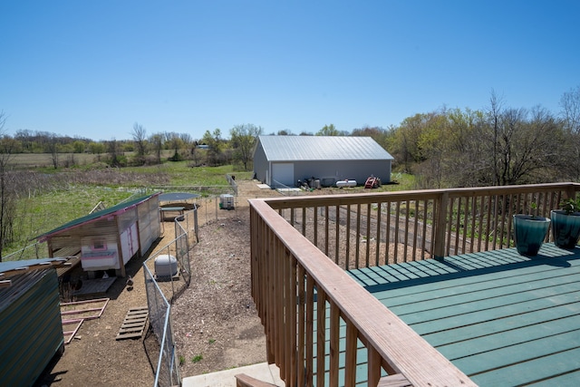 wooden terrace featuring a garage and an outdoor structure