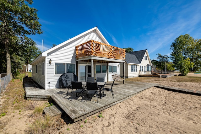 back of property featuring a balcony and a deck