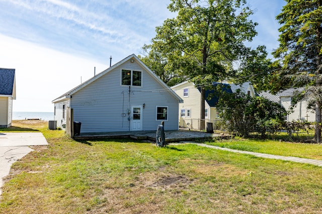 rear view of property with a patio area, a yard, and central AC