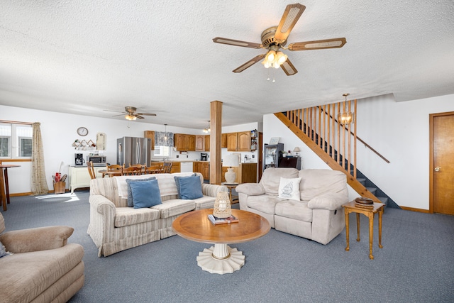 living room featuring carpet flooring, ceiling fan, and a textured ceiling