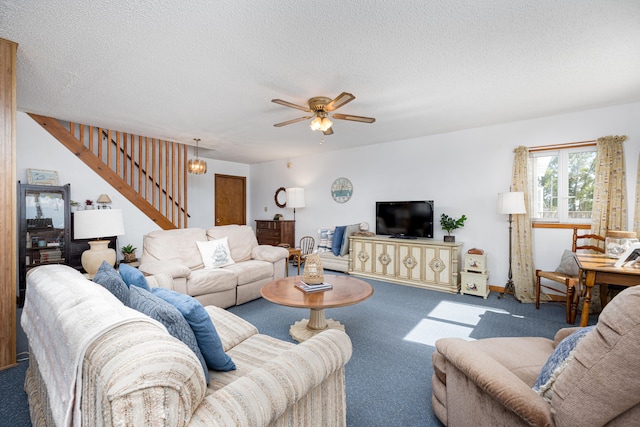 carpeted living room featuring ceiling fan and a textured ceiling