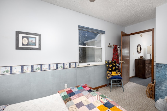 bedroom featuring light carpet and a textured ceiling