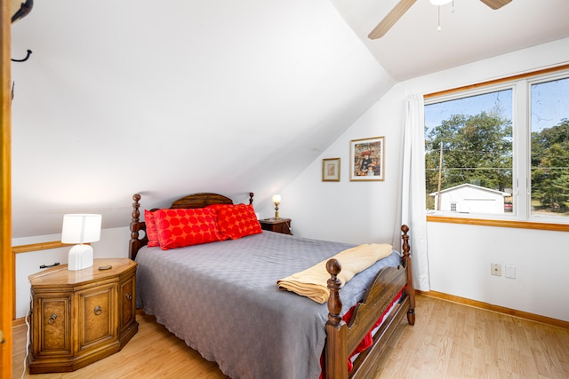 bedroom with light hardwood / wood-style floors, vaulted ceiling, and ceiling fan