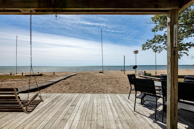 wooden deck with a water view and a view of the beach