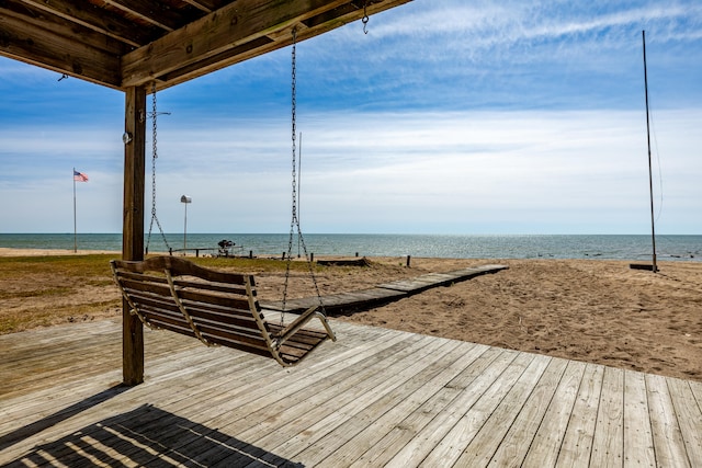 wooden deck with a beach view and a water view