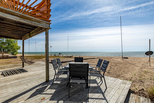 wooden deck featuring a water view and a view of the beach