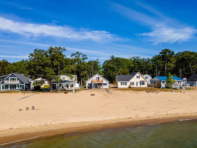 view of yard with a water view and a beach view