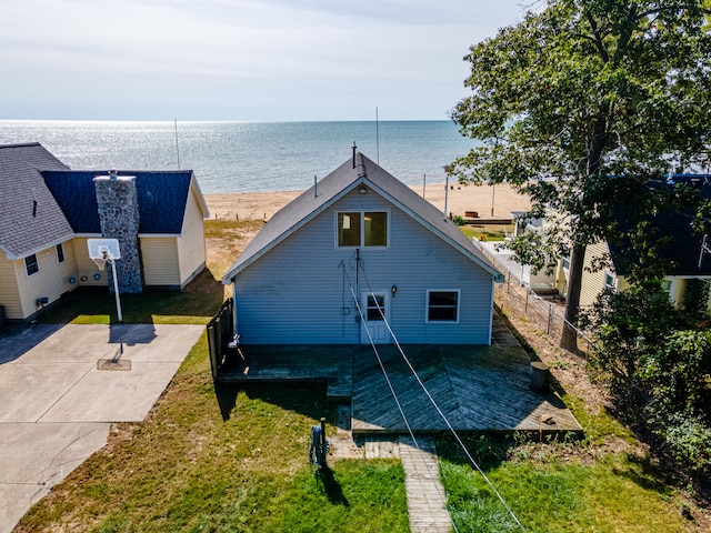back of house with a lawn, a water view, and a patio