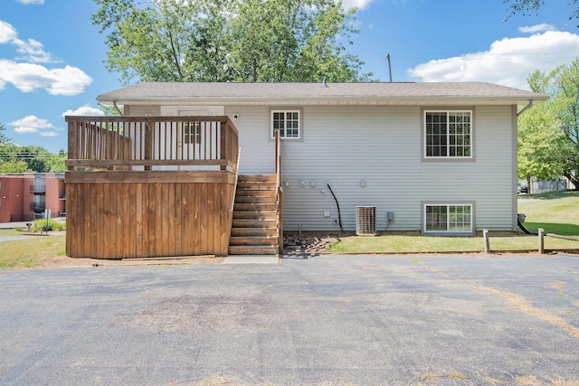 rear view of property with a wooden deck and central AC unit