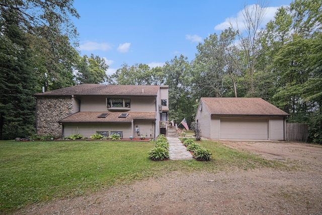 view of front facade with a front yard, an outdoor structure, and a garage