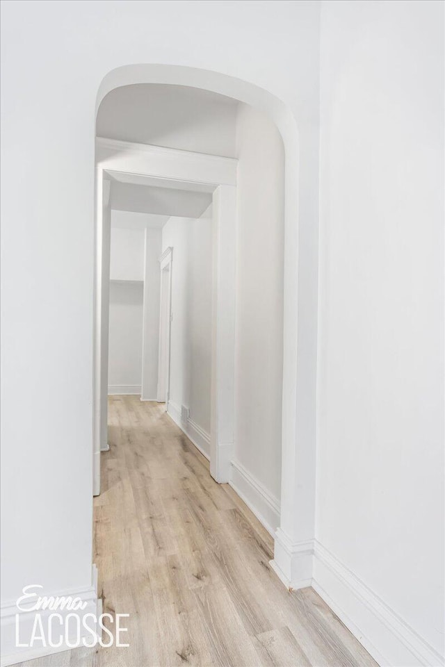 318 Diamond Ave SE, Grand Rapids, MI 49506 - hallway featuring light wood-style floors, arched walkways, and baseboards