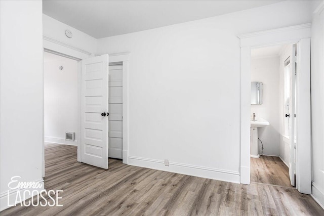 318 Diamond Ave SE, Grand Rapids, MI 49506 - unfurnished bedroom featuring wood finished floors and baseboards