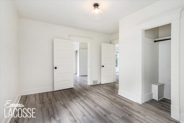 318 Diamond Ave SE, Grand Rapids, MI 49506 - unfurnished bedroom featuring wood finished floors, ornamental molding, and baseboards