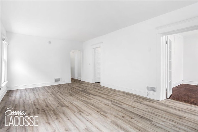 318 Diamond Ave SE, Grand Rapids, MI 49506 - spare room with arched walkways, wood finished floors, and baseboards