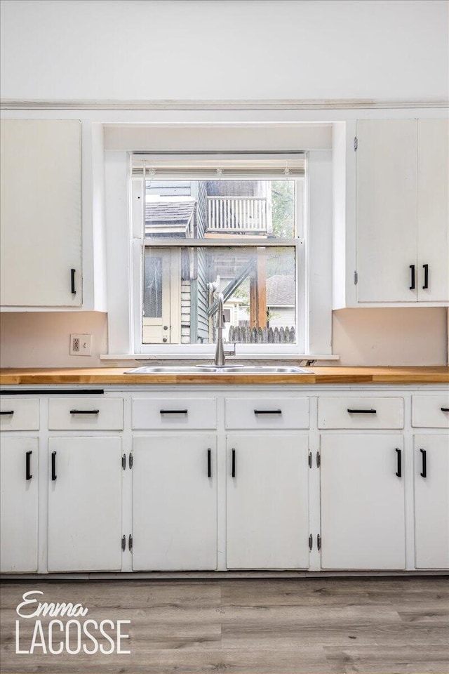 318 Diamond Ave SE, Grand Rapids, MI 49506 - kitchen featuring a sink, wood counters, white cabinetry, and light wood-style flooring