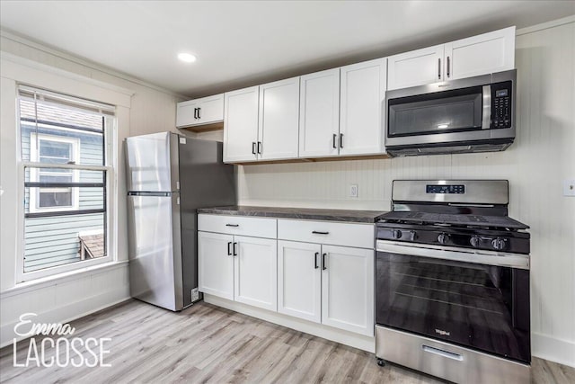 318 Diamond Ave SE, Grand Rapids, MI 49506 - kitchen featuring appliances with stainless steel finishes, white cabinetry, dark countertops, and light wood-style flooring