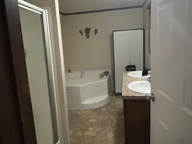 bathroom with ornamental molding, vanity, and a bathing tub