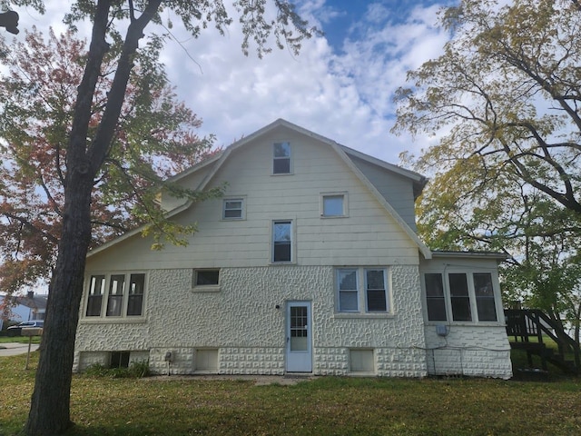 rear view of property featuring a lawn