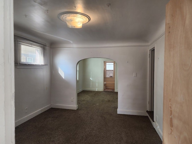 unfurnished room with dark colored carpet