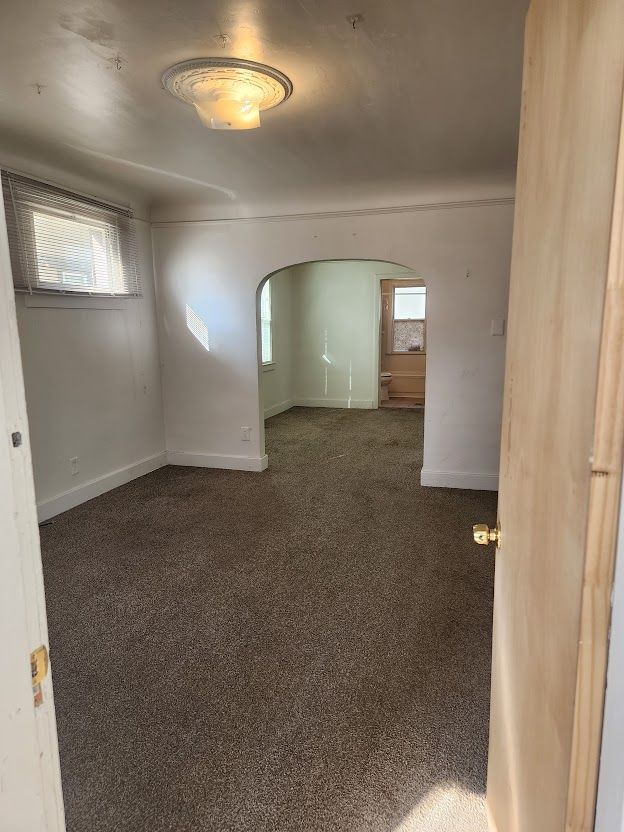 spare room with dark colored carpet