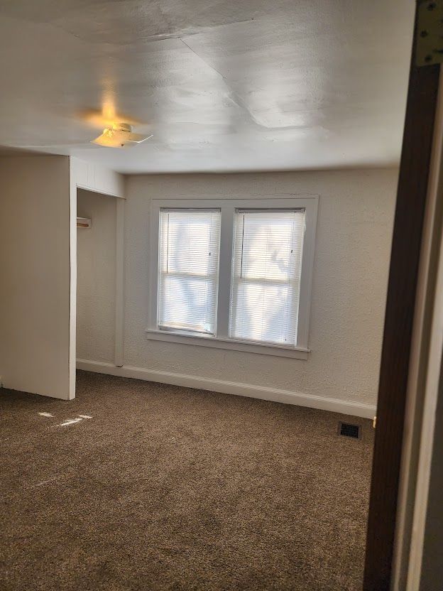 unfurnished bedroom with carpet flooring, a closet, and ceiling fan