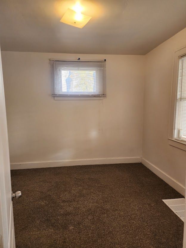 empty room with dark colored carpet