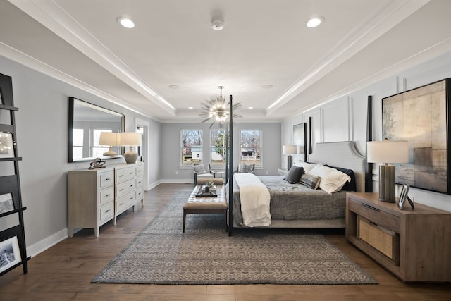 bedroom with dark hardwood / wood-style flooring, a tray ceiling, an inviting chandelier, and crown molding